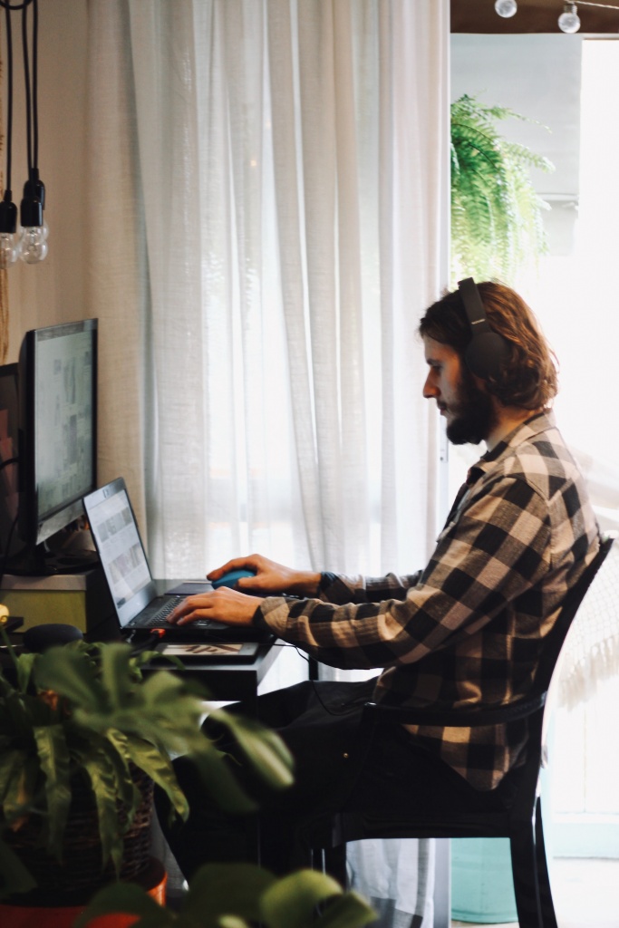 A man using headphones and typing on a computer