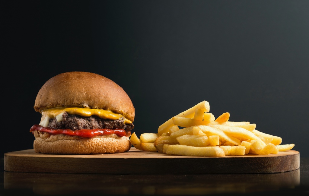 A burger and french fries with excess fat