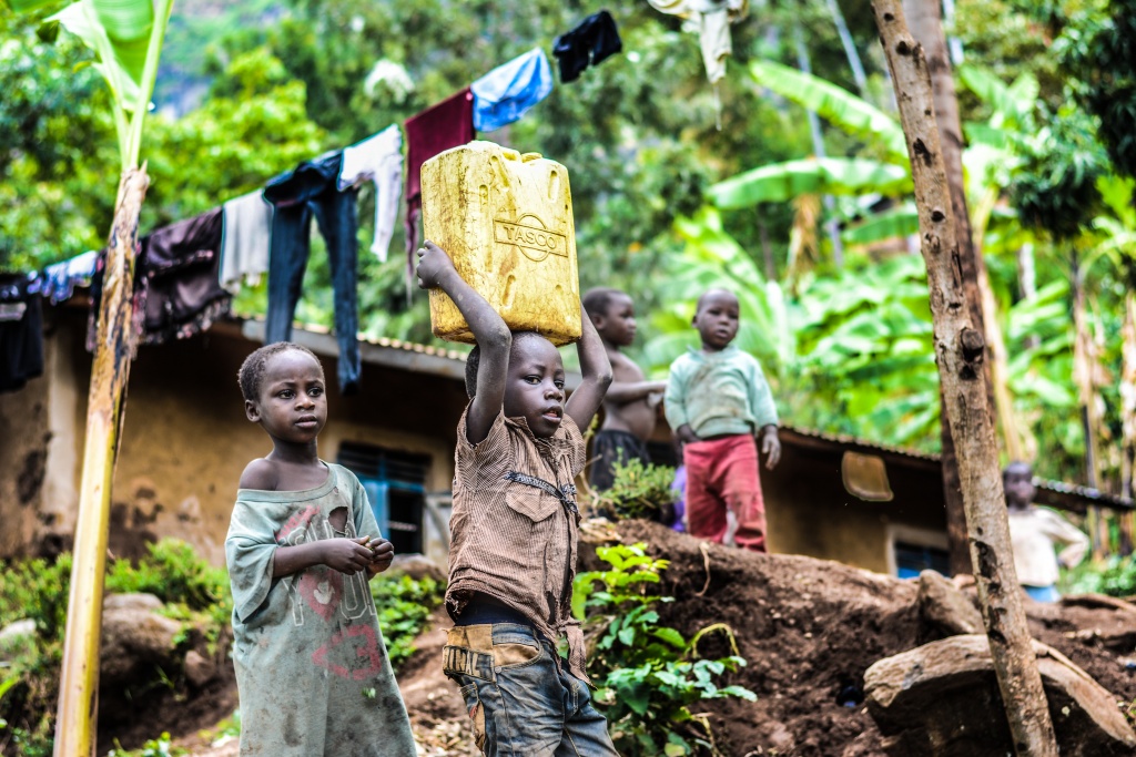 A poor little boy fetching water with a gallon