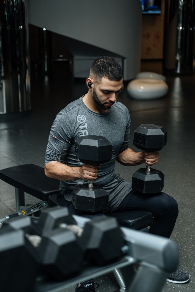 A man lifting hand weights to build his arm strength