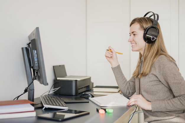 Smiling woman on a desk wearing headphones