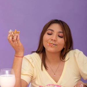 woman eating many kinds of sugar desserts